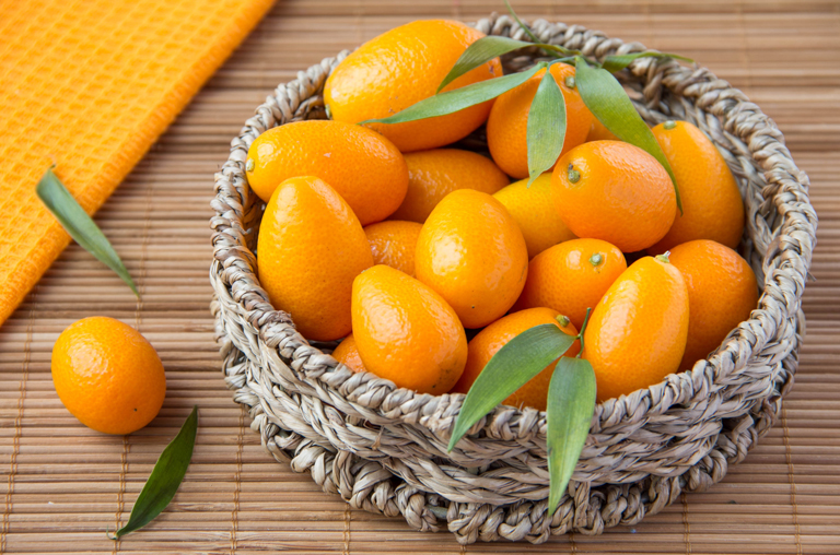 Kumquats in einem Holzkorb