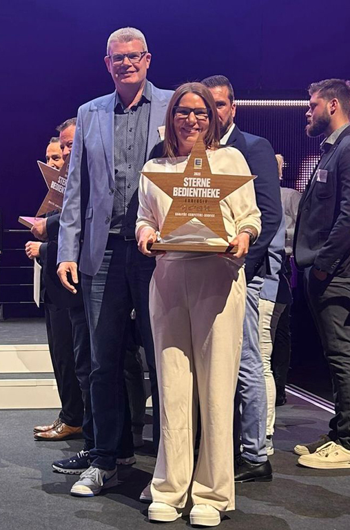 Große Freude: Frank Deckenbach und Bedientheken-Abteilungsleiterin Sabrina Kredel mit dem Pokal