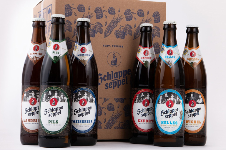 Verschiedene Biere von Schlappeseppel vor einem Holzkarton
