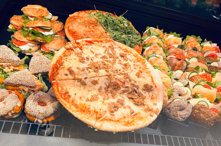Selbst gemachte Snacks und Pizza in der Auslage der Marktbäckerei von EDEKA Deckenbach