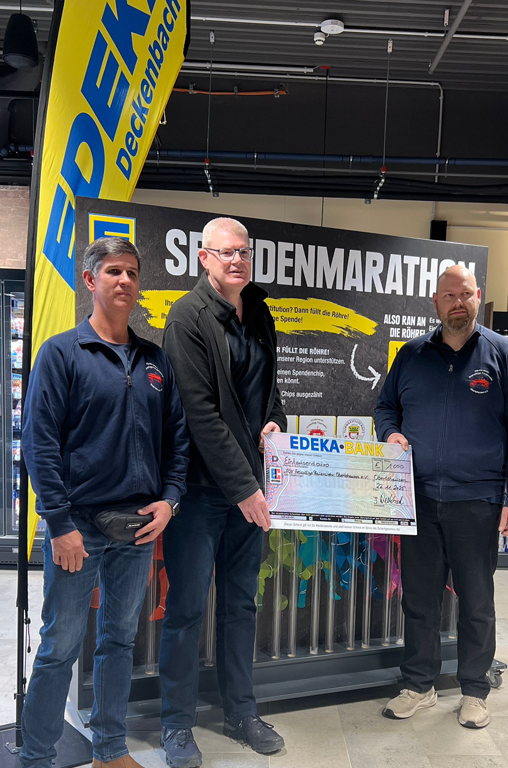 Frank Deckenbach (mitte) bei der Übergabe des Siegerschecks an den Förderverein Freiwillige Feuerwehr Obertshausen